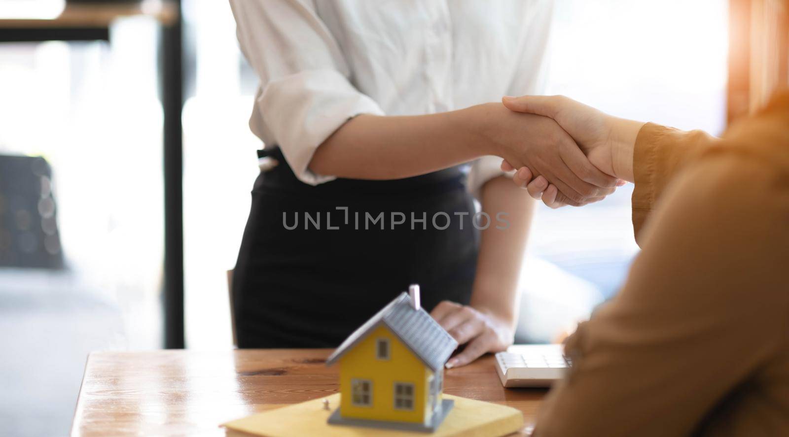 Real estate agents and customers shake hands to congratulate on signing a contract to buy a house with land and insurance, handshake and Good response concept..
