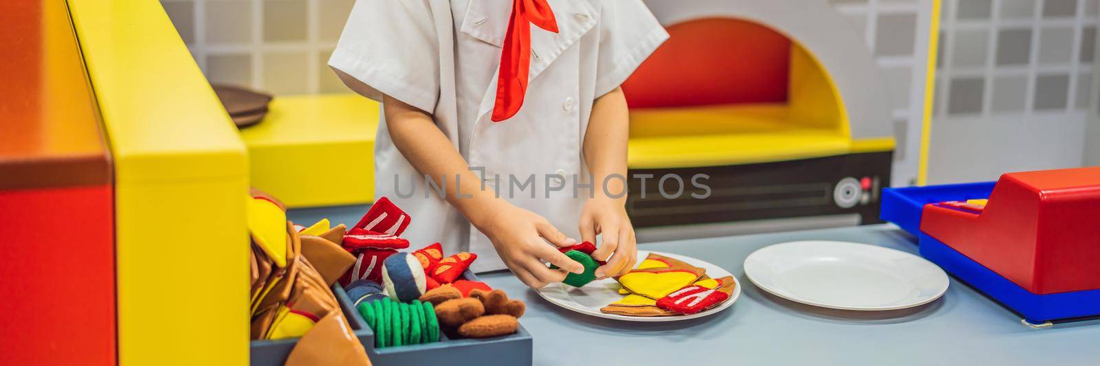 The boy plays in the toy kitchen, cooks a pizza BANNER, LONG FORMAT by galitskaya