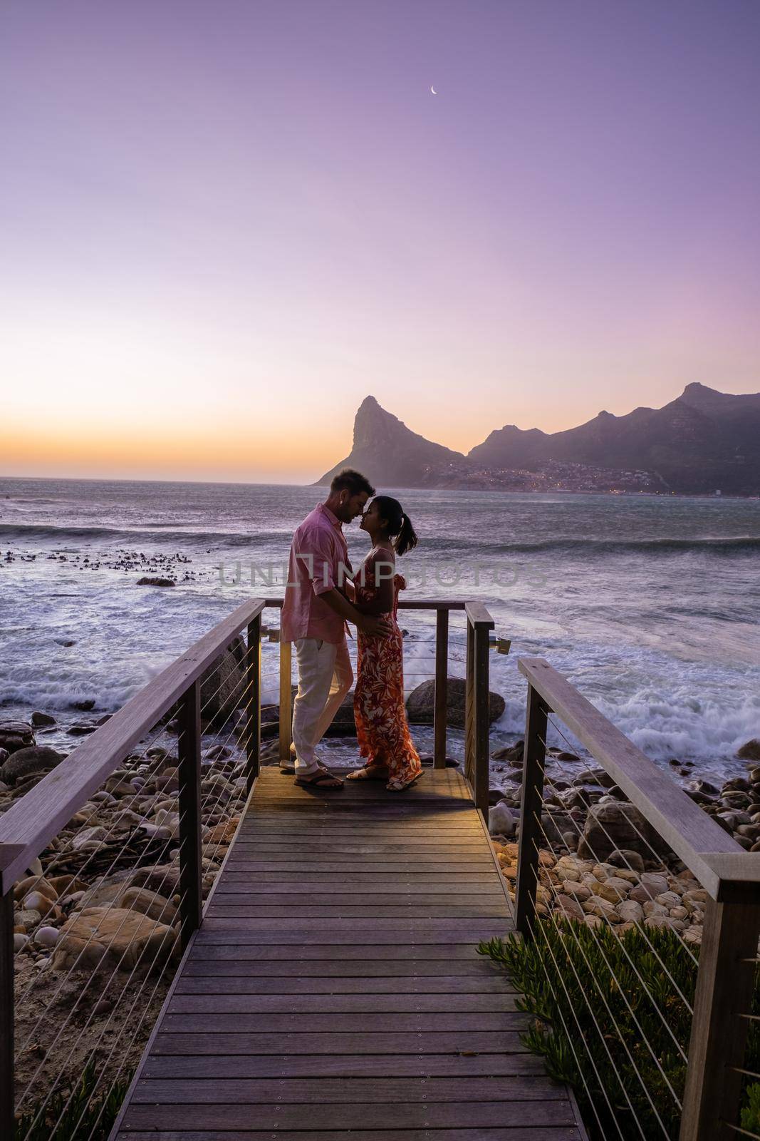 couple man and women drinking coffee during on balcony sunrise at vacation in Cape Town South Africa.