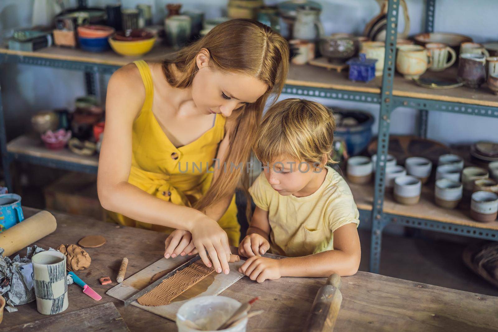 mother and son doing ceramic pot in pottery workshop.