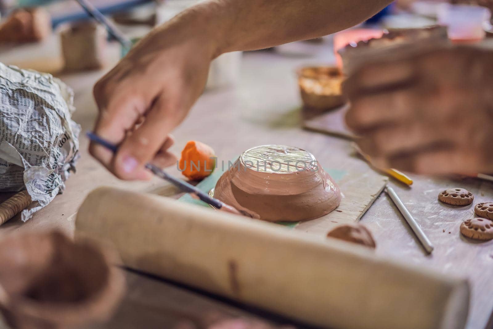 Father and son doing ceramic pot in pottery workshop by galitskaya