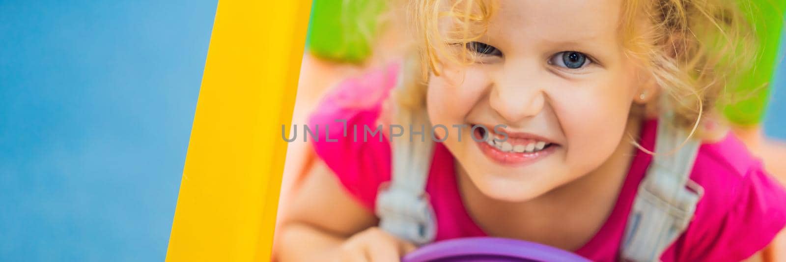 Little girl rides a toy colorful car. BANNER, LONG FORMAT