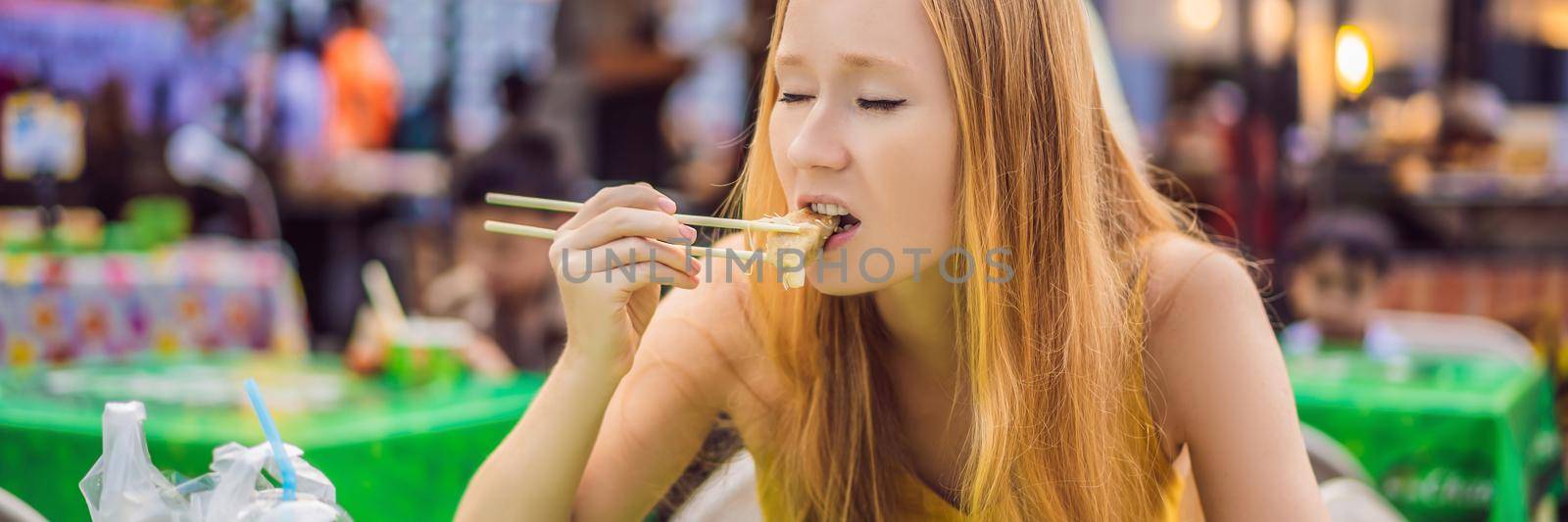 happy cute gilr eating street food and looking enjoyable in a traditional small fair. BANNER, LONG FORMAT