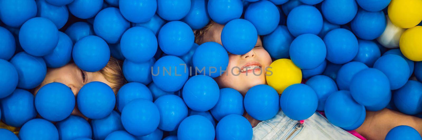 BANNER, LONG FORMAT Child playing in ball pit. Colorful toys for kids. Kindergarten or preschool play room. Toddler kid at day care indoor playground. Balls pool for children. Birthday party for active preschooler.