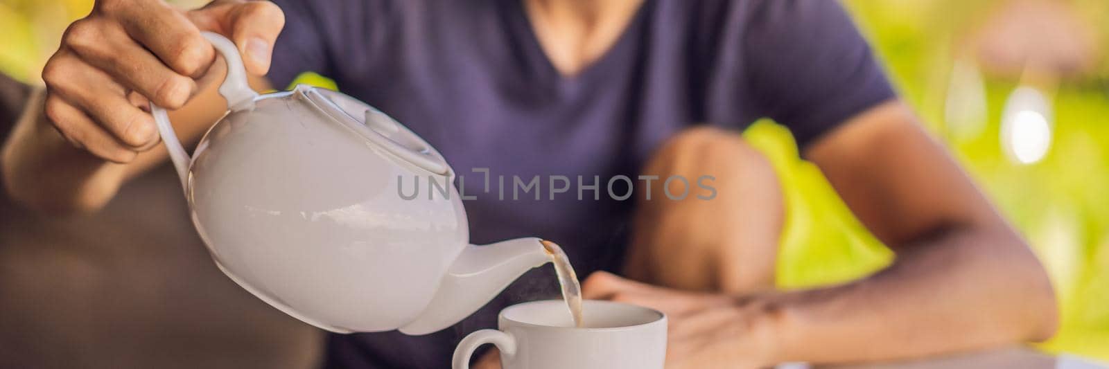 Man with a cup of tea on the cafe veranda near the rice terraces on Bali, Indonesia. BANNER, LONG FORMAT