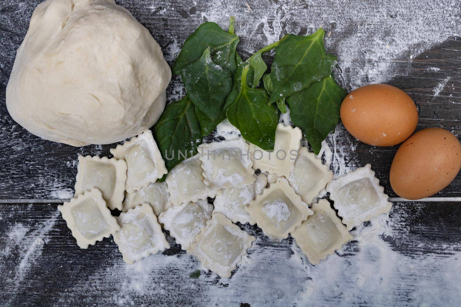 dough with spinach eggs, flour and ravioli on wood by GabrielaBertolini
