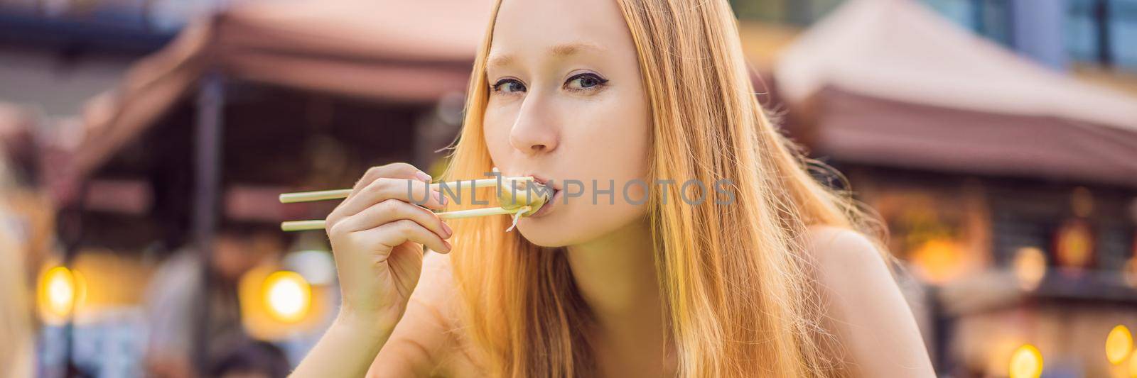 happy cute gilr eating street food and looking enjoyable in a traditional small fair. BANNER, LONG FORMAT