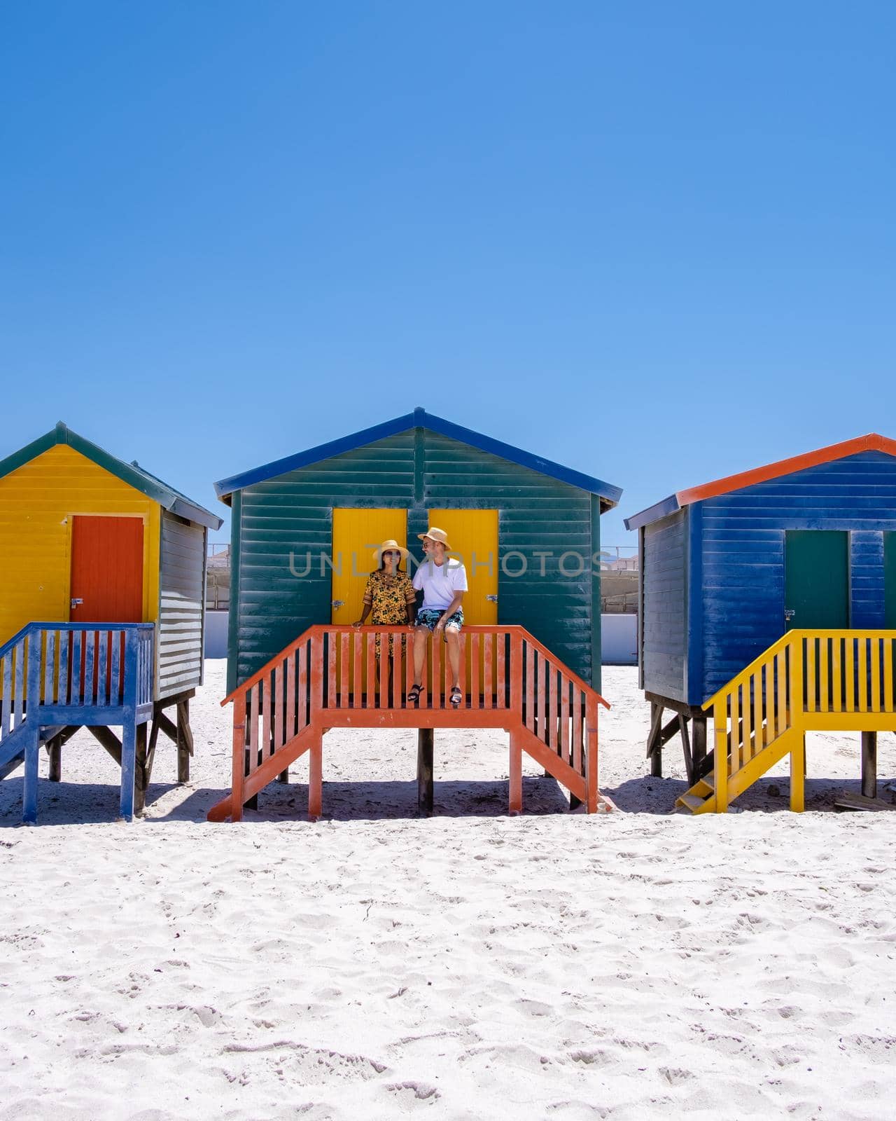 colorful beach house at Muizenberg beach Cape Town, beach huts, Muizenberg, Cape Town, False Bay, South Africa. couple man and woman visiting the beach at Muizenberg