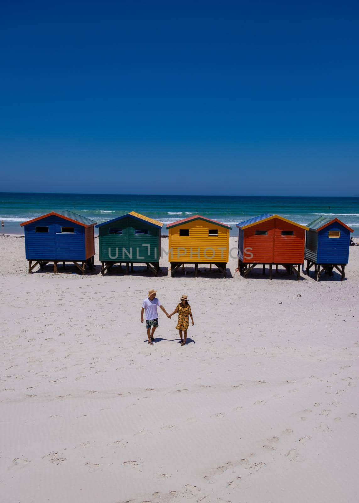 colorful beach house at Muizenberg beach Cape Town, beach huts, Muizenberg, Cape Town, False Bay, South Africa. couple man and woman visiting the beach at Muizenberg