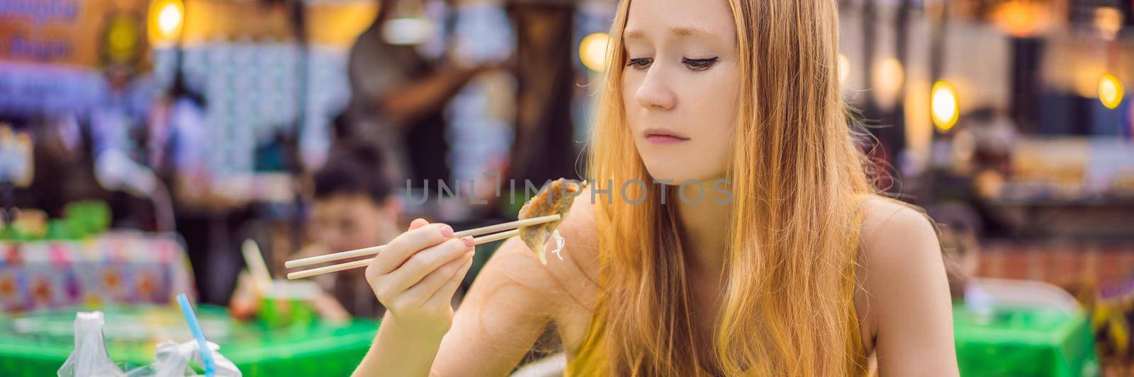 happy cute gilr eating street food and looking enjoyable in a traditional small fair. BANNER, LONG FORMAT