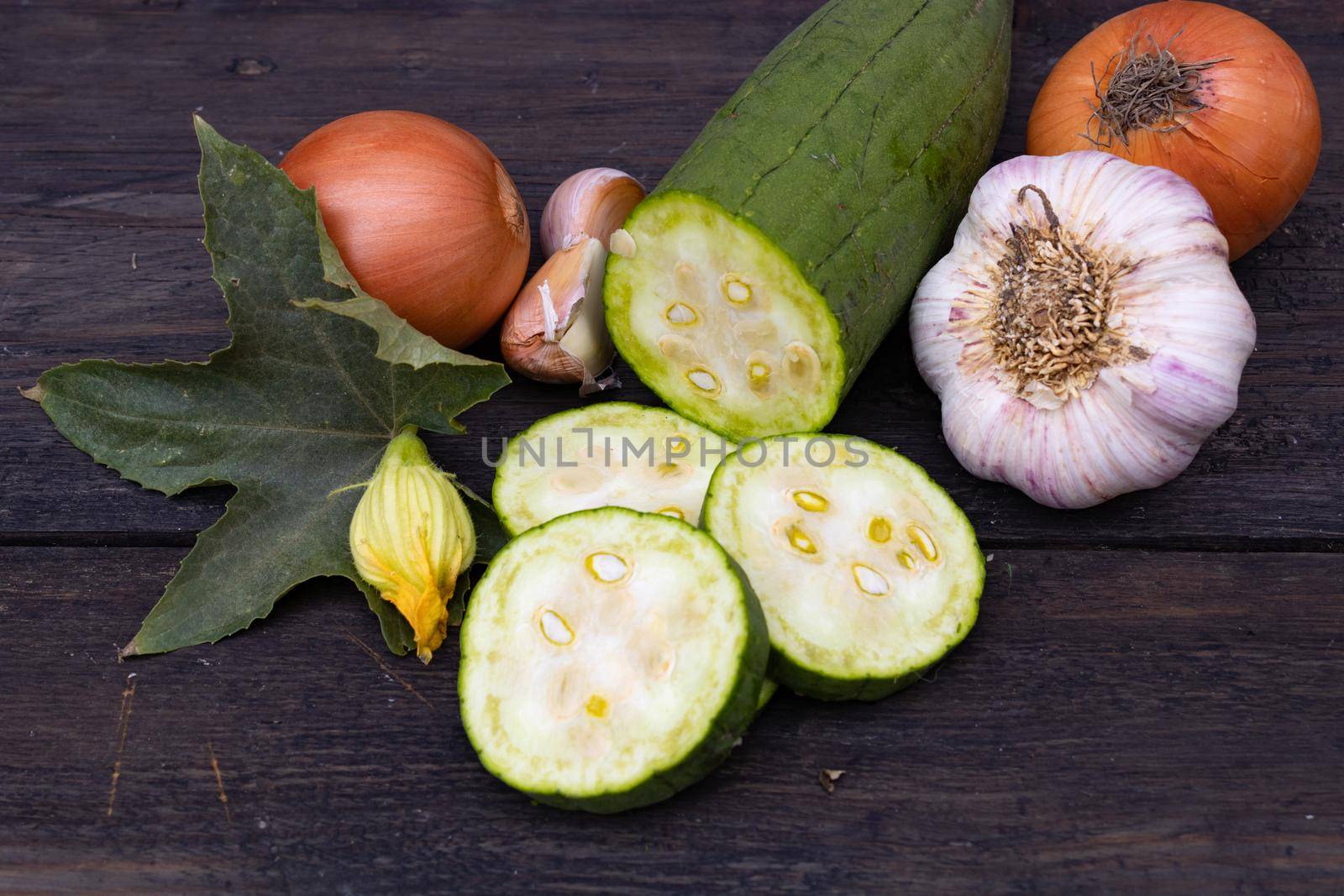 cuisine with luffa garlic and onion on rustic wooden background