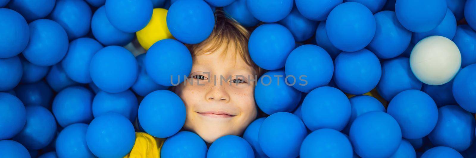 BANNER, LONG FORMAT Child playing in ball pit. Colorful toys for kids. Kindergarten or preschool play room. Toddler kid at day care indoor playground. Balls pool for children. Birthday party for active preschooler by galitskaya
