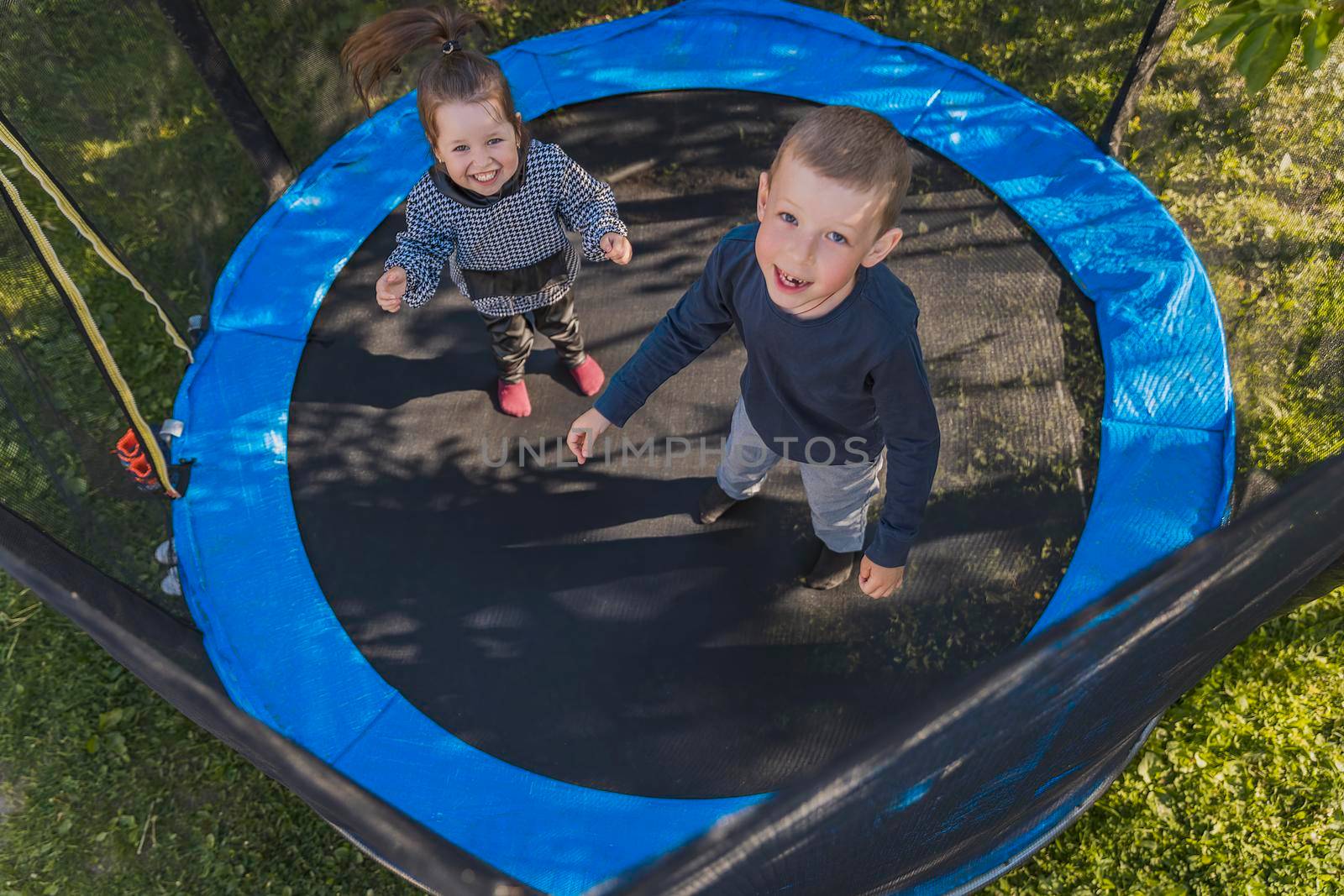 children jumping on a trampoline top view
