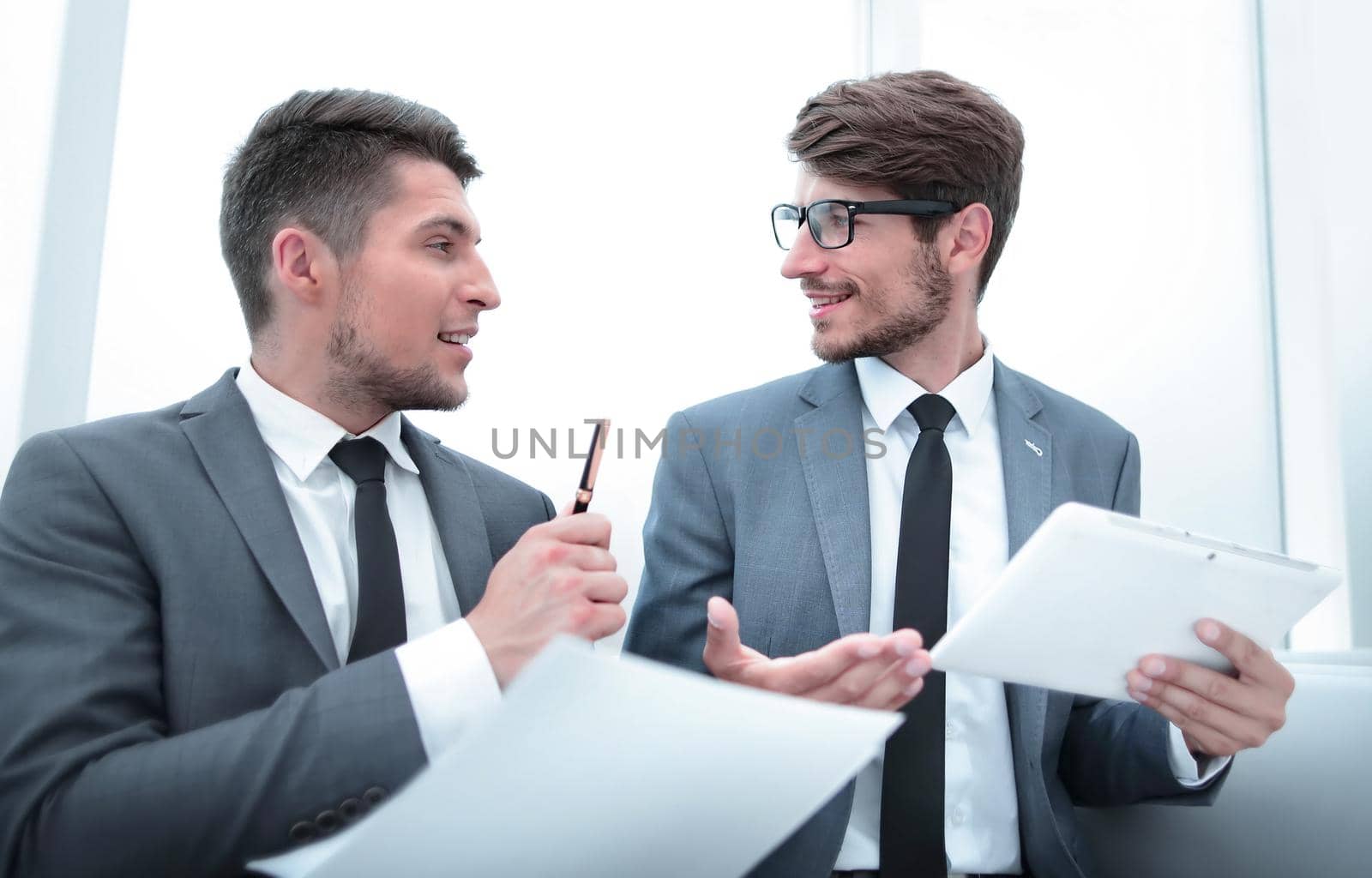 young businesspeople looking at each other and talking at the office by asdf