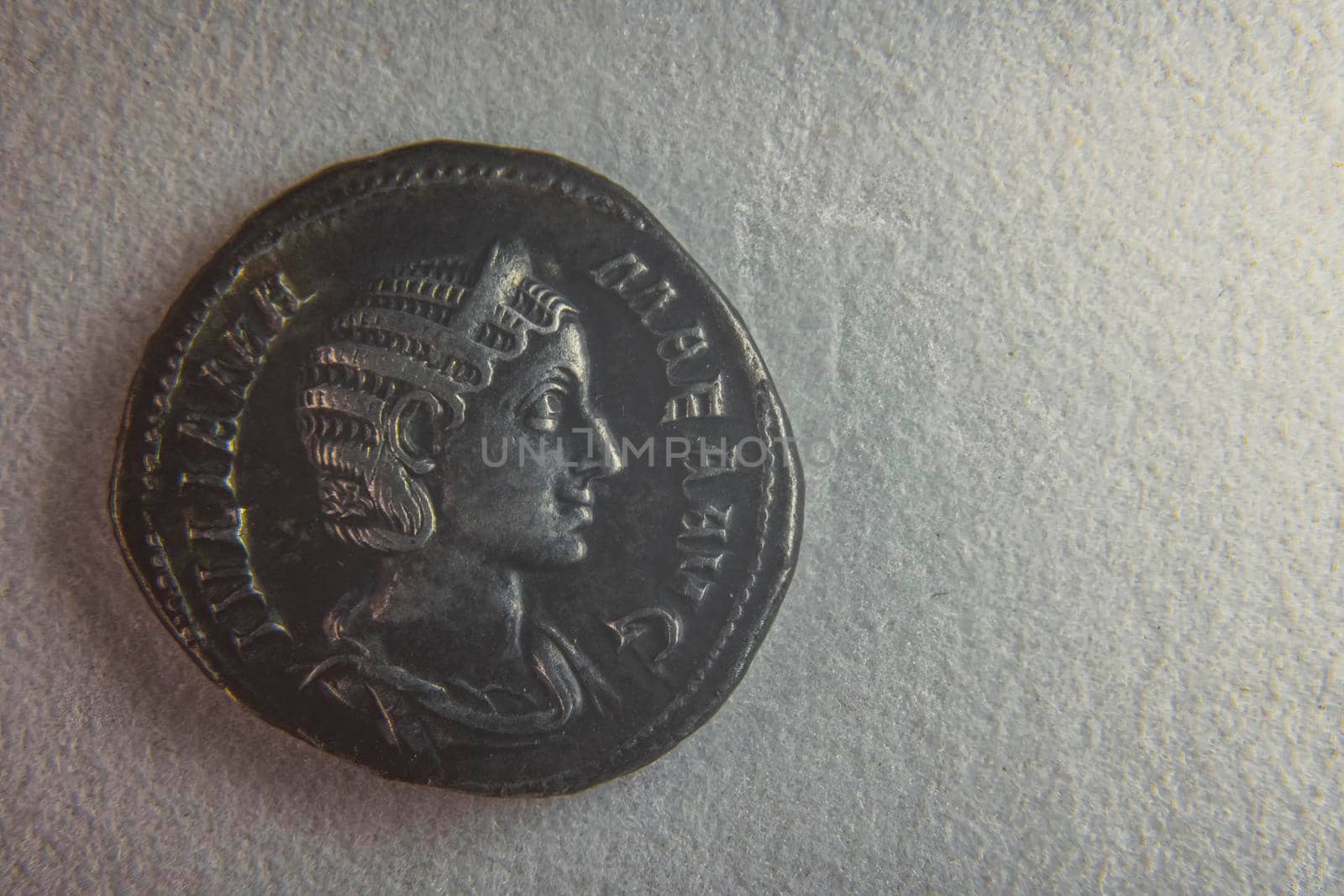 old roman coin on white paper closeup