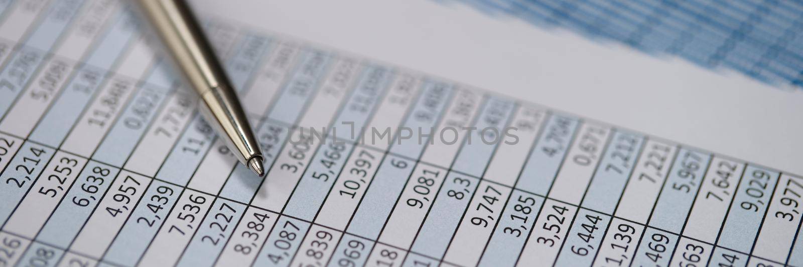 Metal pen lying on documents with graphs closeup. Statistics and audit concept