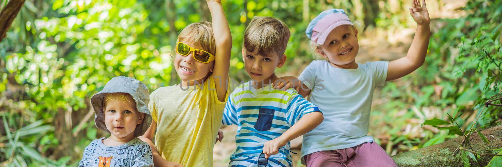 Children rest during a hike in the woods. BANNER, LONG FORMAT