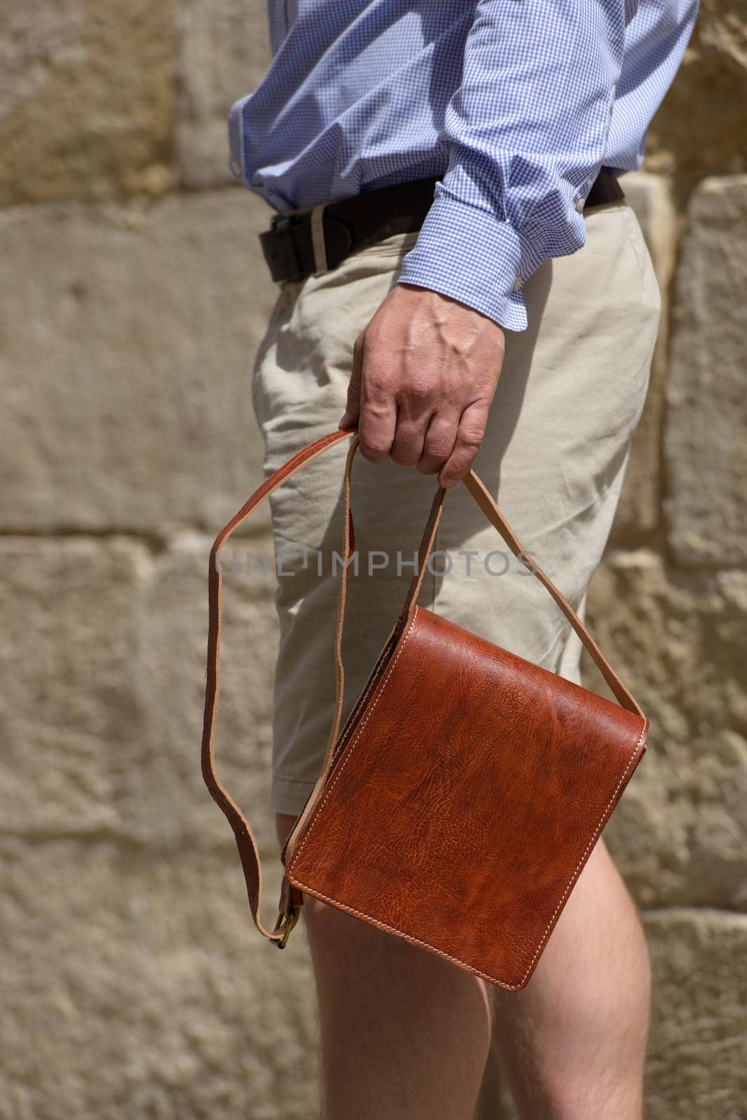 close-up photo of a small orange leather bag in mans hand by Ashtray25