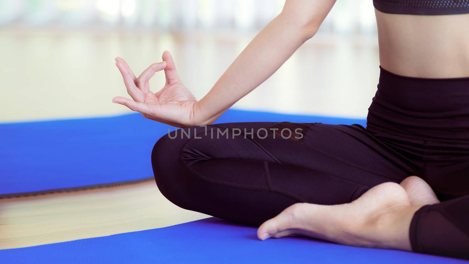 Woman practicing yoga pose in gym, close up view. Healthy lifestyle and wellness concept.