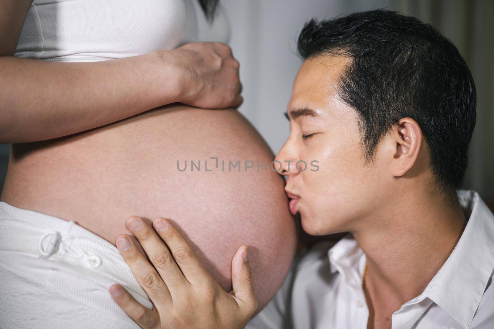 close-up Husband kissing to his wife's belly 