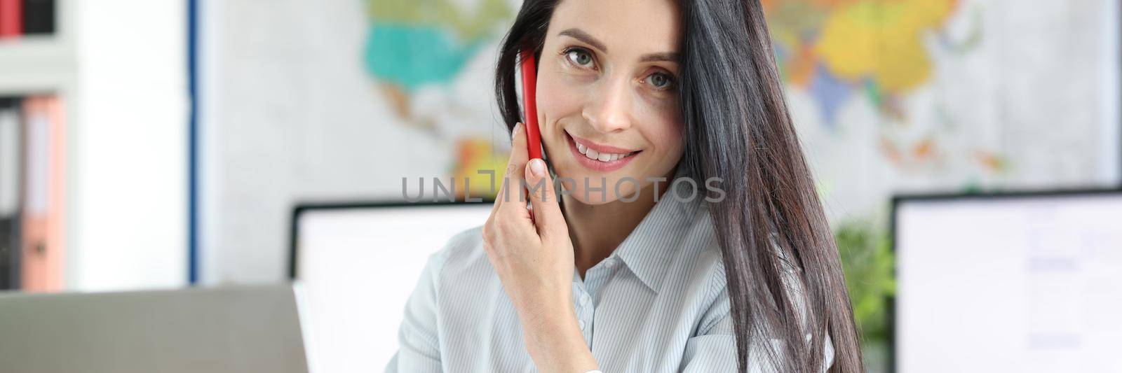 Beautiful woman manager in the office talking on the phone. Comfortable workspace, modern interior