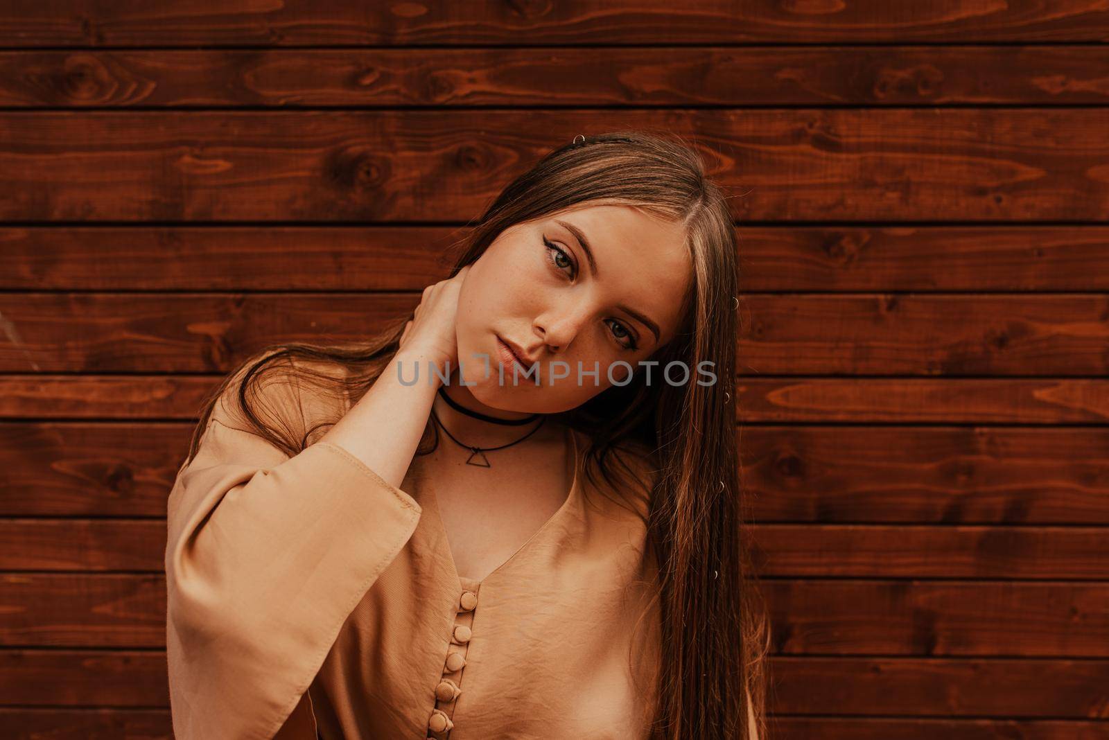 Ukrainian young woman in a mini skirt. Fashion summer 2021 style glamorous. Brown wooden striped background.