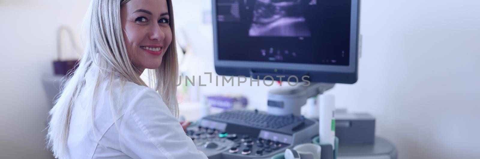 Joyful female ultrasound doctor conducts an abdominal examination. A gynecologist determines a woman's pregnancy, radiologist