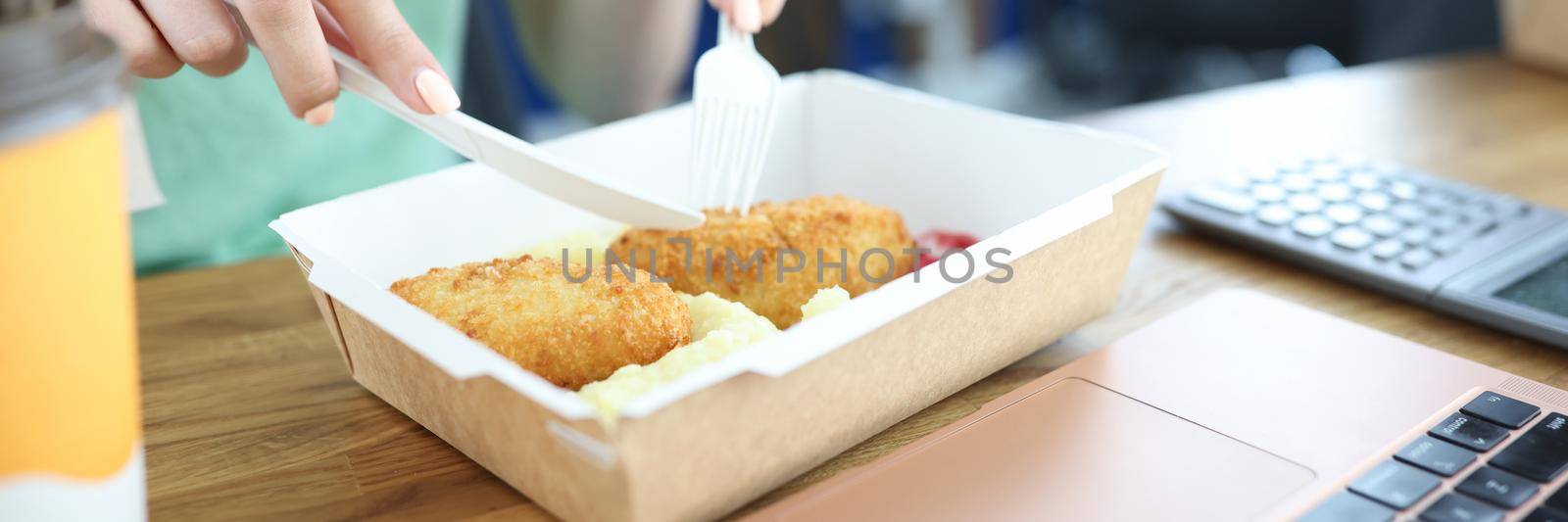 The woman eats alone in the dining room, disposable tableware. Lunch delivery to the office, food close up