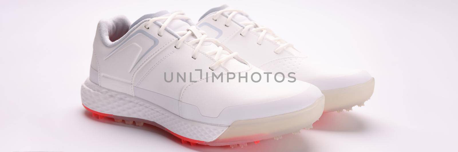 Fashionable women's white sneakers with laces on a paper sheet, close-up. Selling shoes via the Internet, taking photos of trendy things