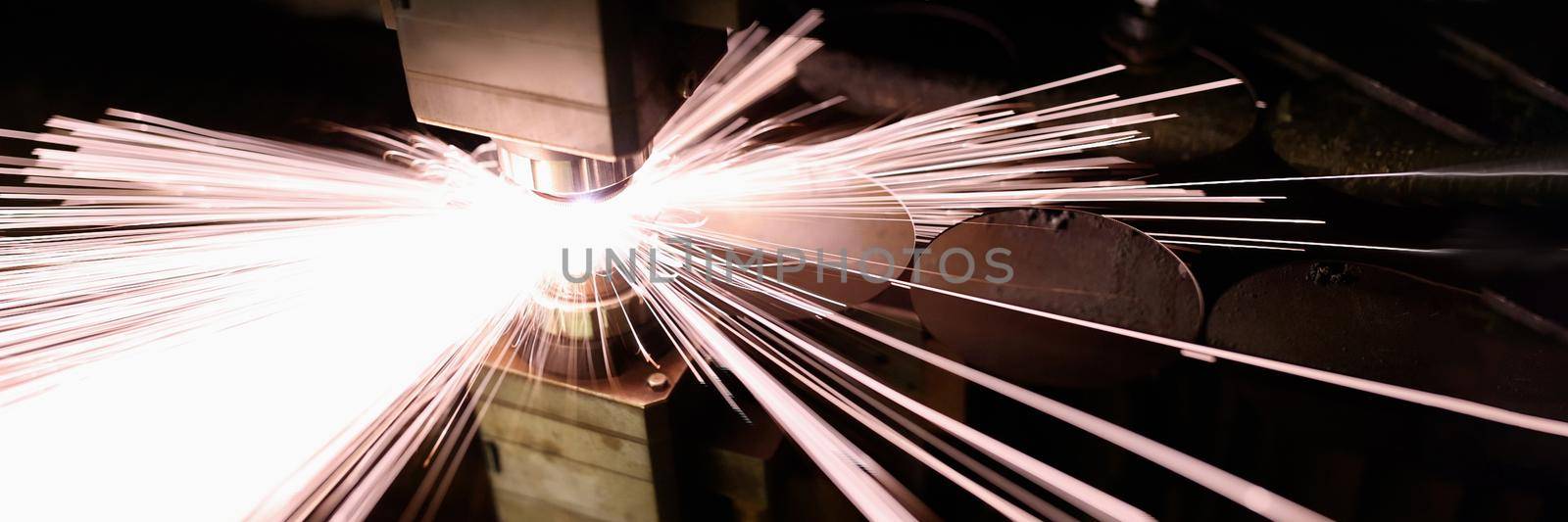 Bright sparks from metal welding in production, close-up. Factory machine, industrial equipment, workplace
