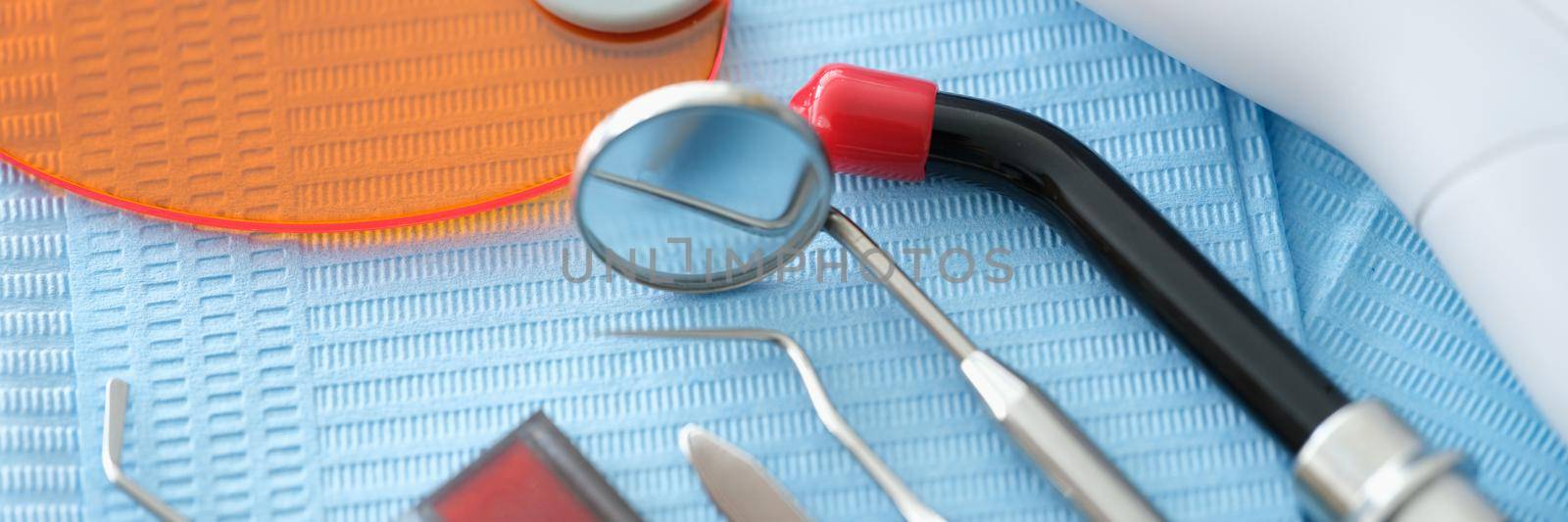 Dental instruments and denture lie on a blue medical napkin by kuprevich