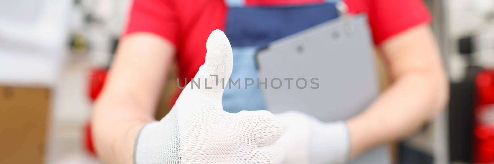 Male courier shows ok gesture with a gloved hand, close-up. Service of delivery of documents and parcels