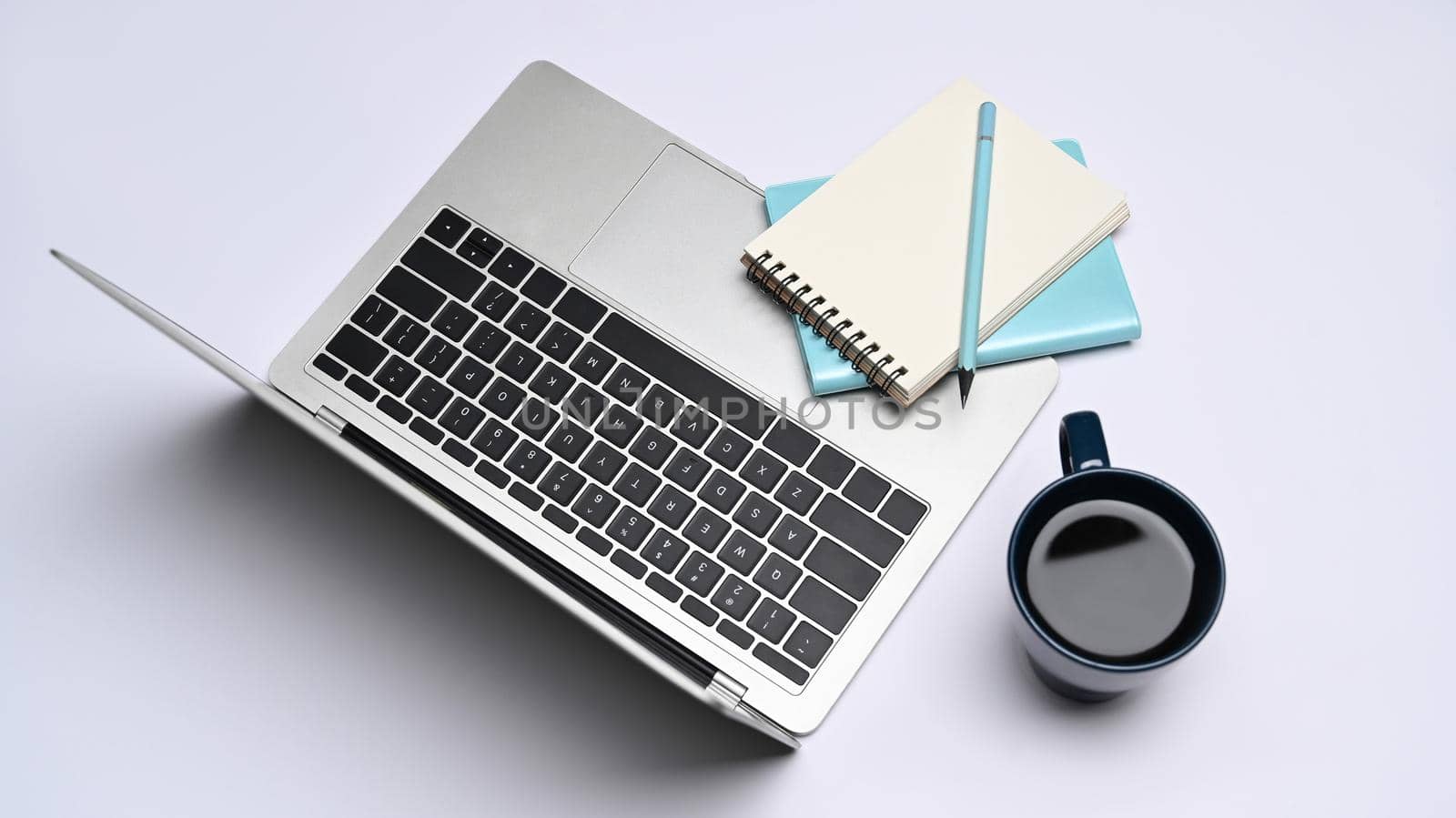 Laptop computer, notebook and coffee cup on white background. Top view. by prathanchorruangsak