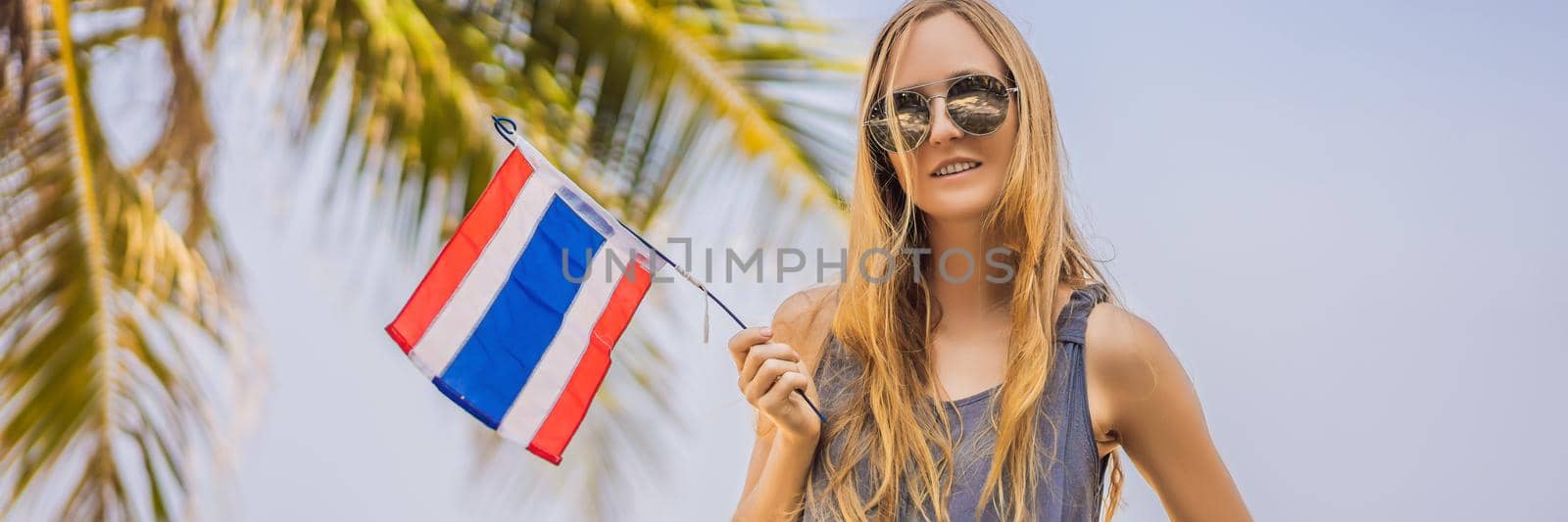 Happy woman having fun at the beach with Thailand flag. Beautiful girl enjoying travel to Asia. BANNER, LONG FORMAT
