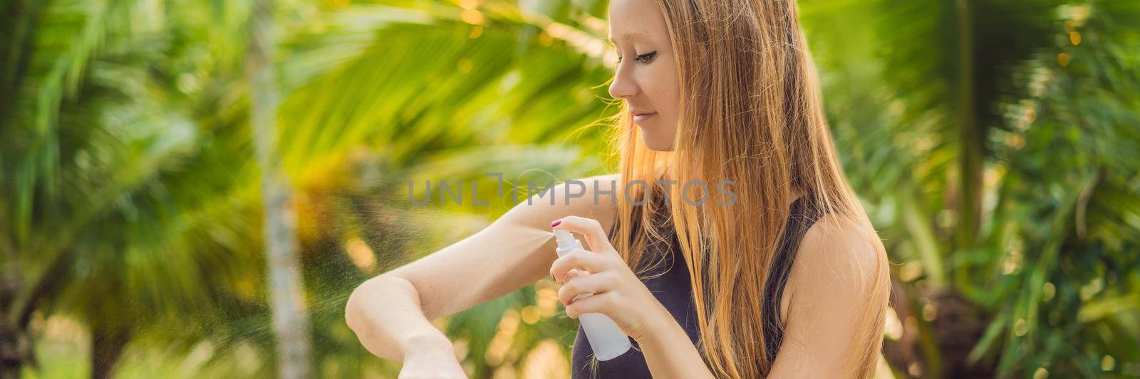 Woman spraying insect repellent on skin outdoor. BANNER, LONG FORMAT