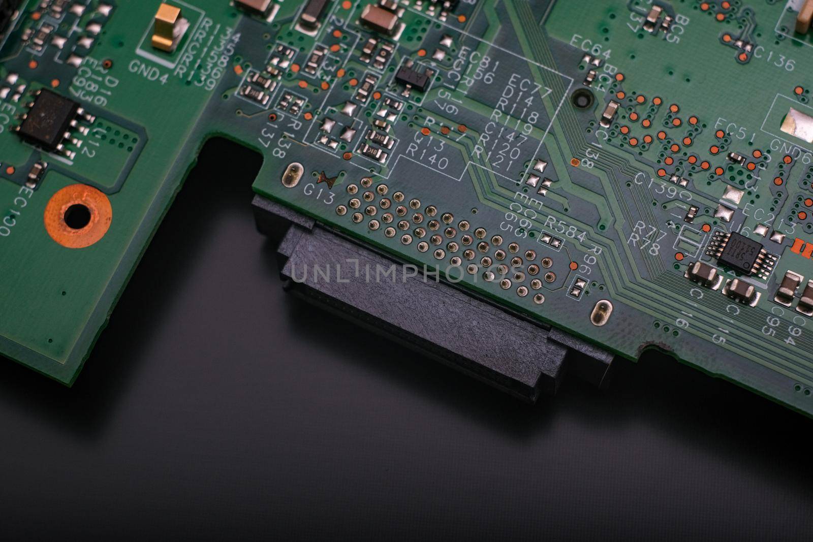 Electronic components. Integrated circuits, resistors, transistors and capacitors on PCB. Green copper board detail. Standard color code. Old computer hardware.