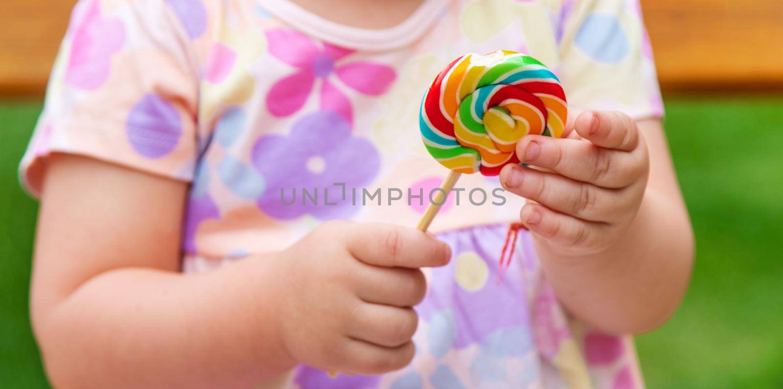 Baby eats a lollipop in the park. Selective focus. Child.