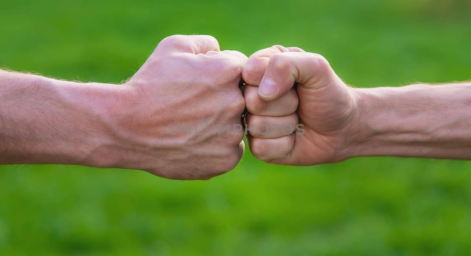 Fists of men at a meeting in the park. Selective focus. People.