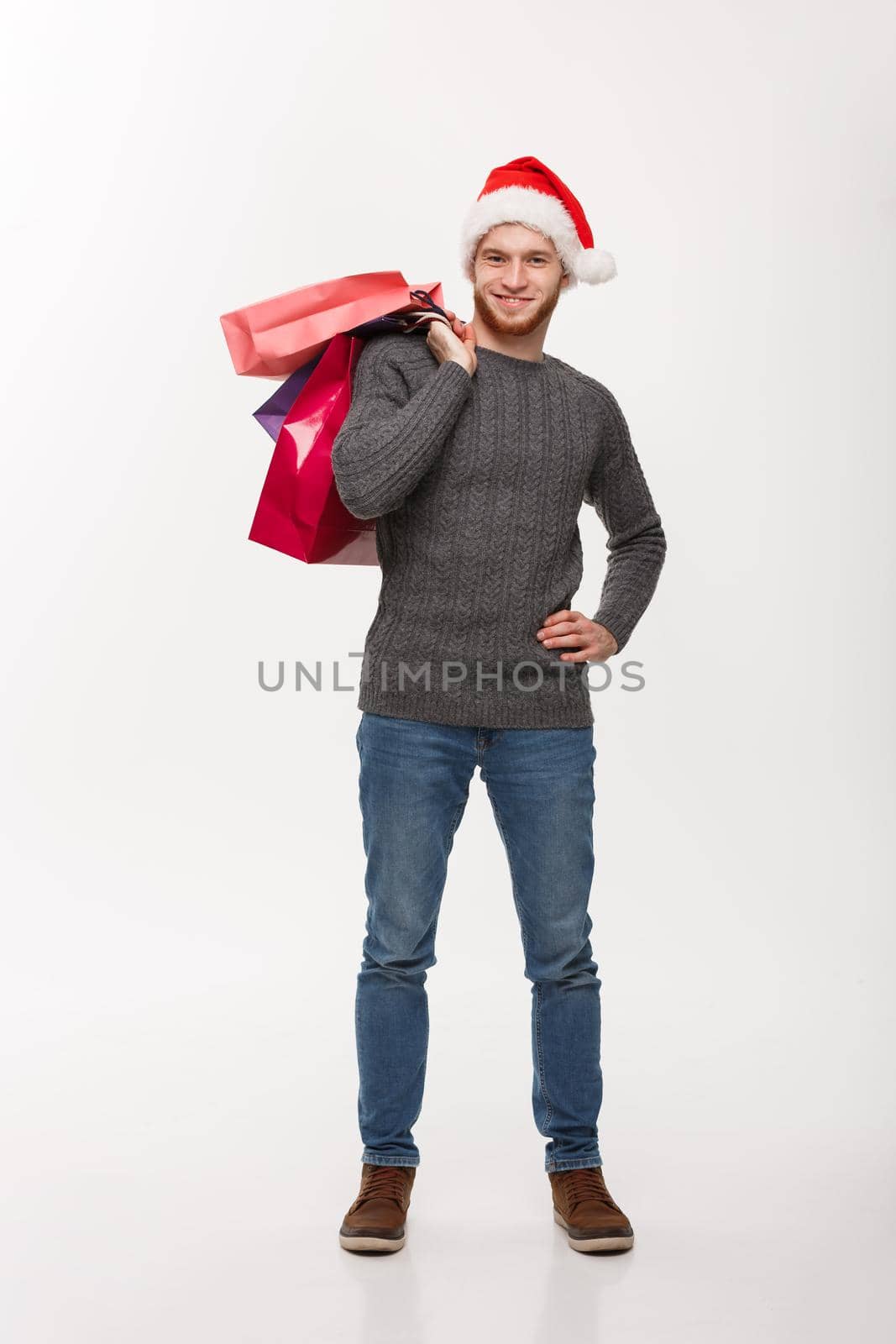 Christmas Concept - Young handsome beard man happy with shopping bag in the hand isolated on white.
