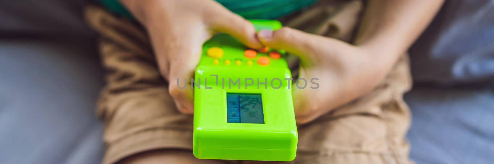 Young boy playing old school portable game console, electronic retro pocket toy with monochrome display BANNER, LONG FORMAT by galitskaya