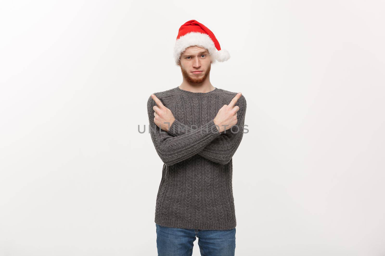 Holiday Concept - Young beard man in sweater enjoy playing and pointing finger onside with copyspace.