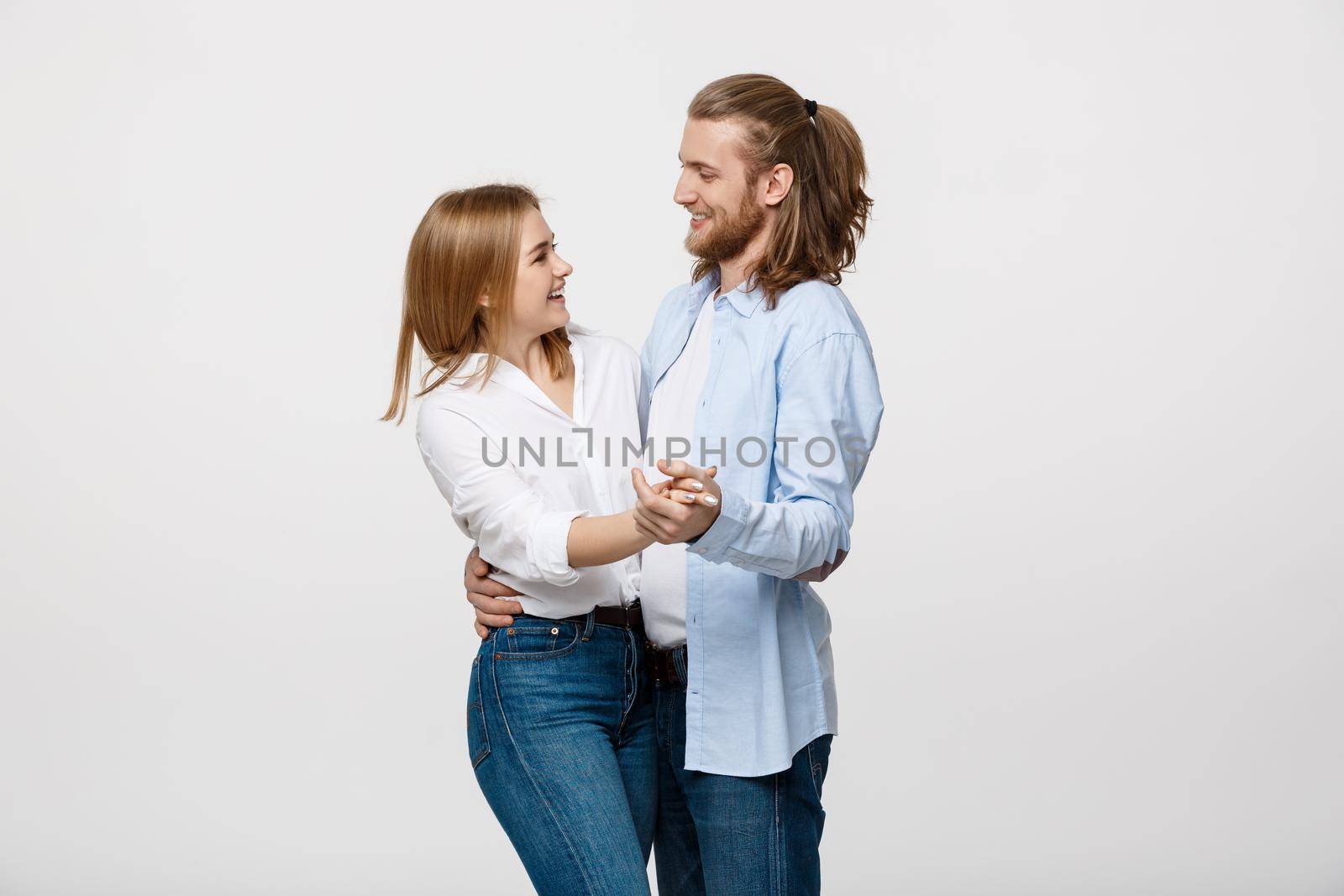 Young elegant couple in casual cloth dancing over Isolated on white studio background. by Benzoix