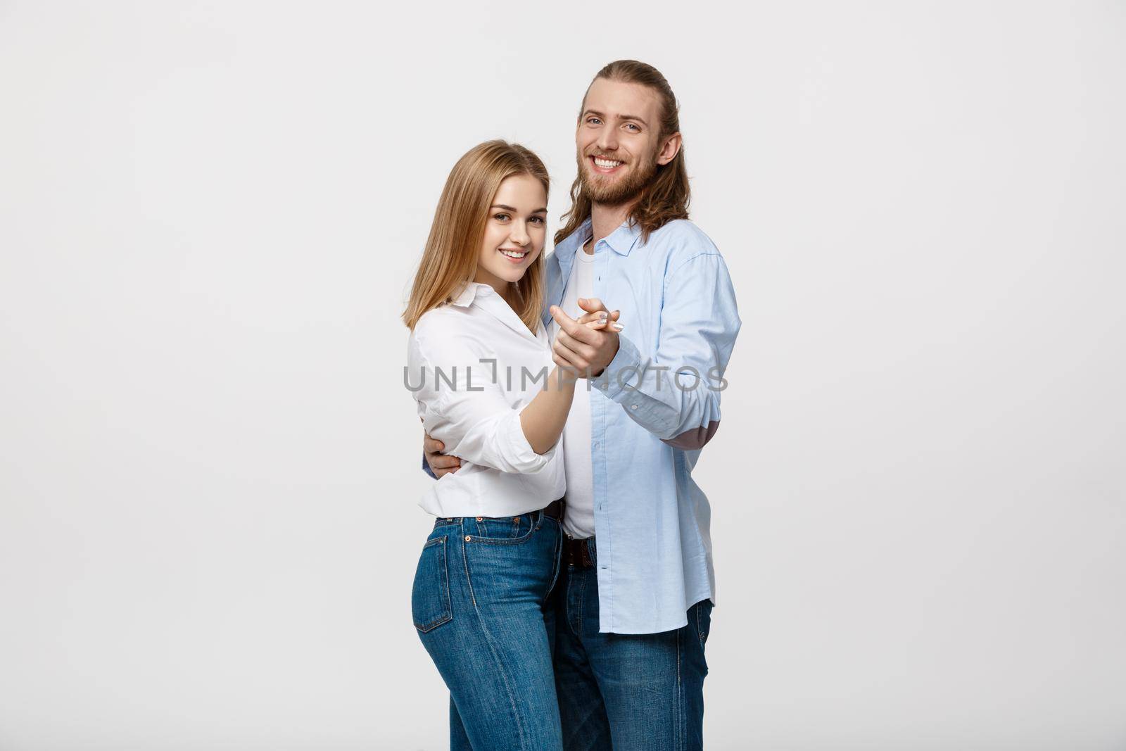 Young elegant couple in casual cloth dancing over Isolated on white studio background. by Benzoix