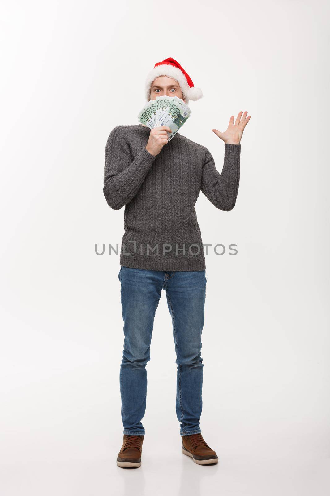 Holiday Concept - young beard man holding money in front over white background by Benzoix