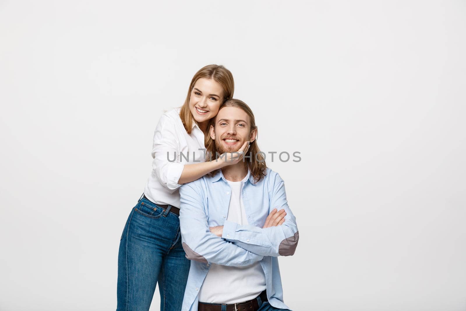 Happy confident young brunette woman smiling and touching her boyfriend chin with love