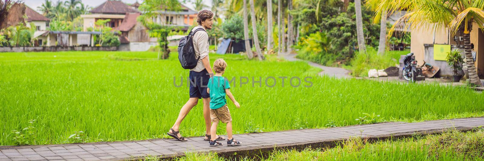 Dad and son travelers on Beautiful Rice Terraces against the background of famous volcanoes in Bali, Indonesia Traveling with children concept. BANNER, LONG FORMAT