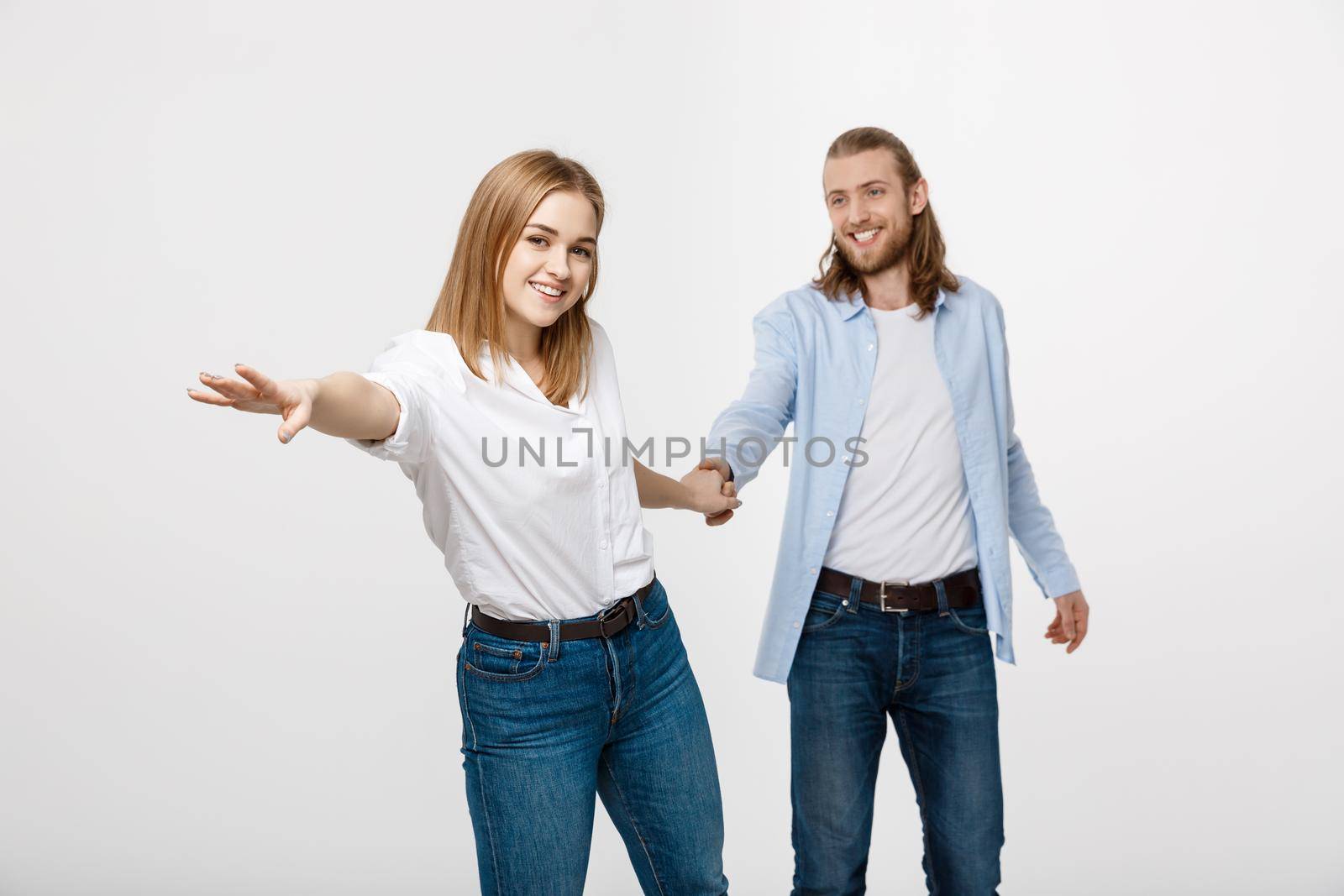 happy loving couple holding hands over white background.