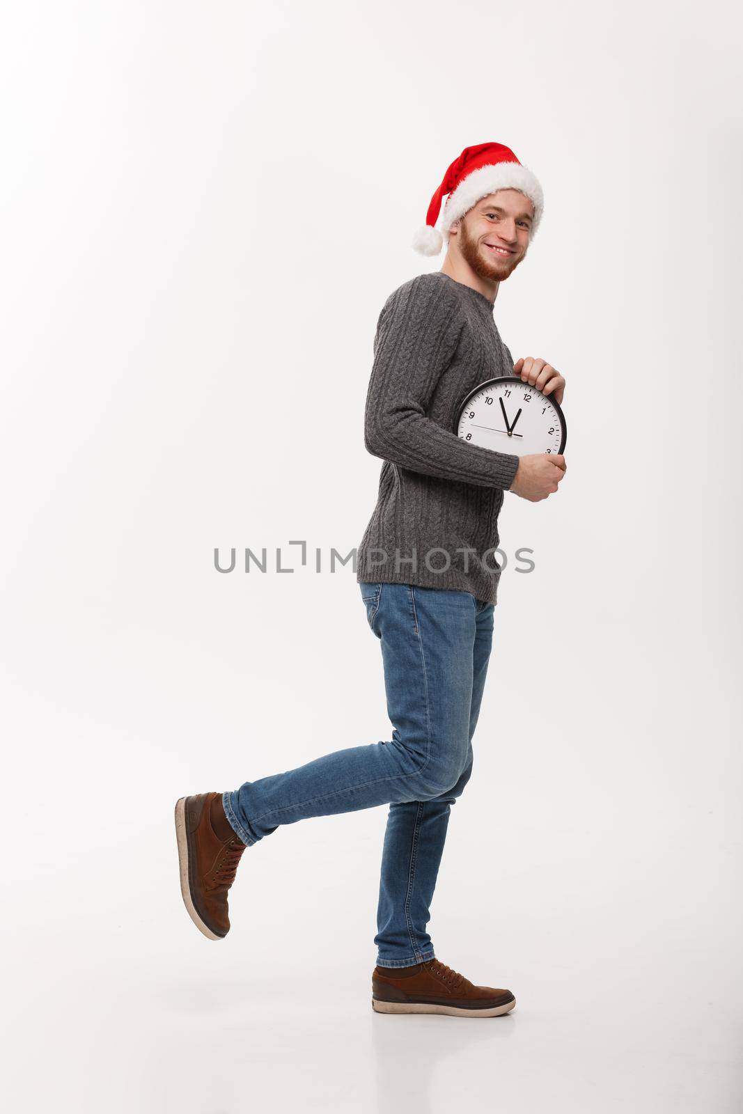 Rush time concept - Young beard smart man running with clock in busy moment over white studio.
