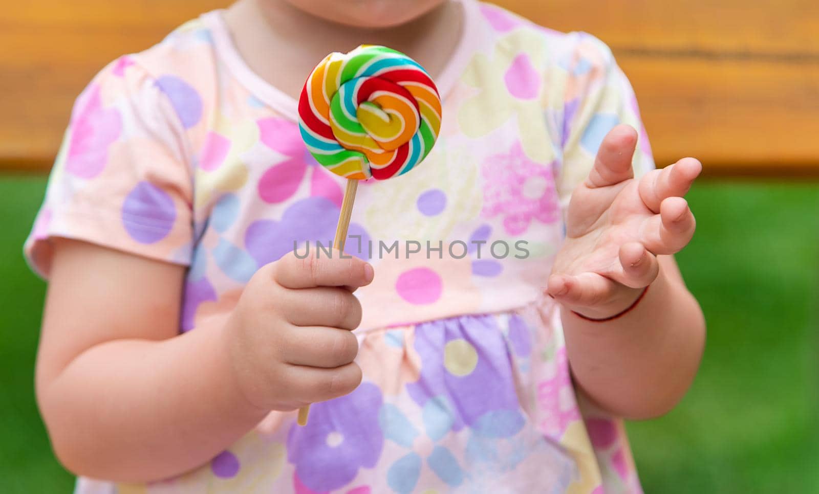 Baby eats a lollipop in the park. Selective focus. Child.