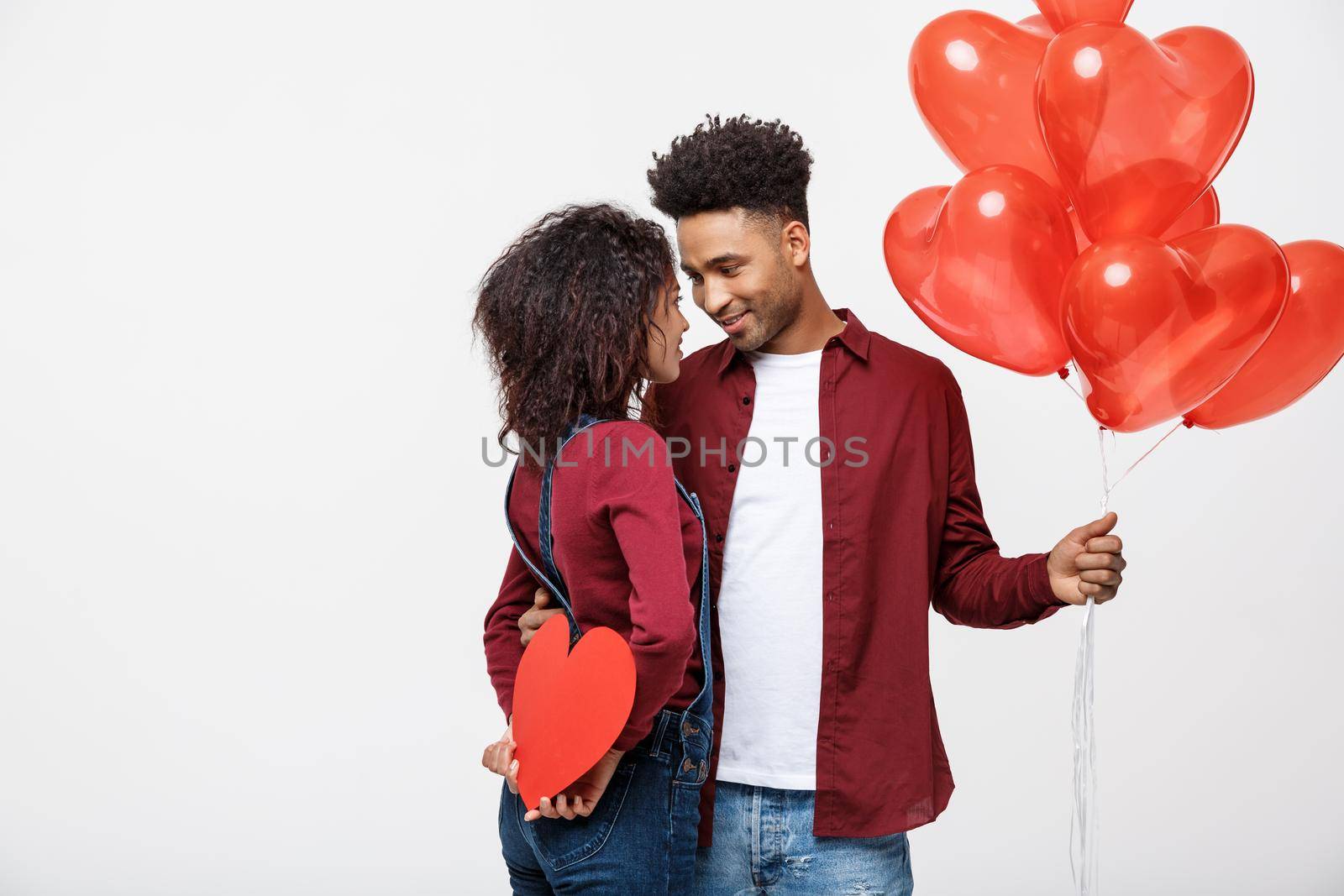 Young attactive African American couple holding heart balloon and paper. by Benzoix